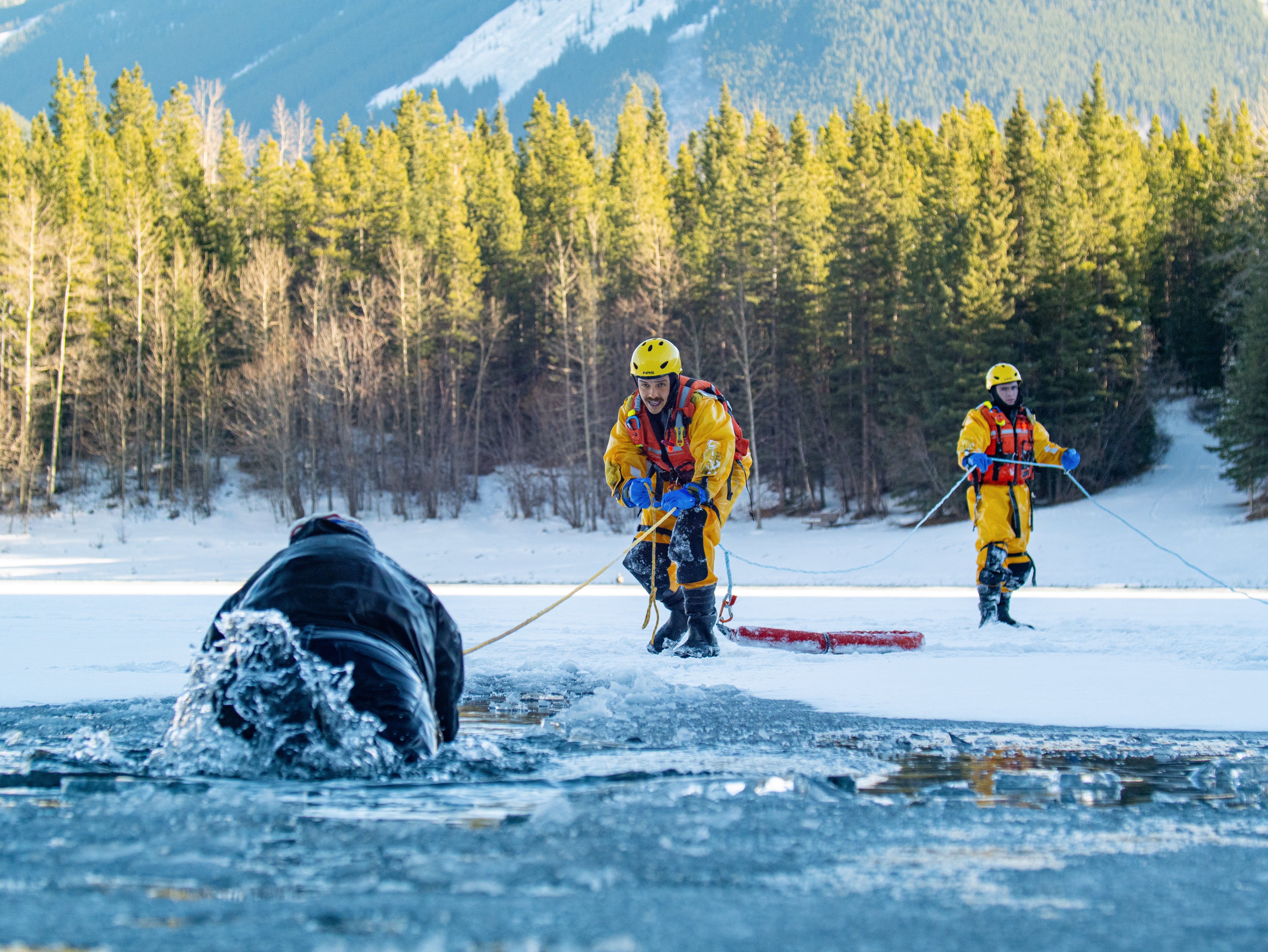 2 rescuers performing a throw rope rescue through the ice