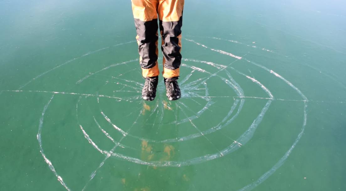 Person standing on ice that is cracking beneath them.