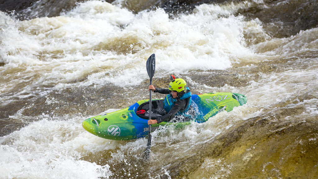 kayaker paddling down a set of rapids