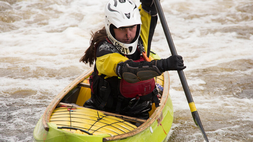 Willa Mason paddling a whitewater canoe (OC1)