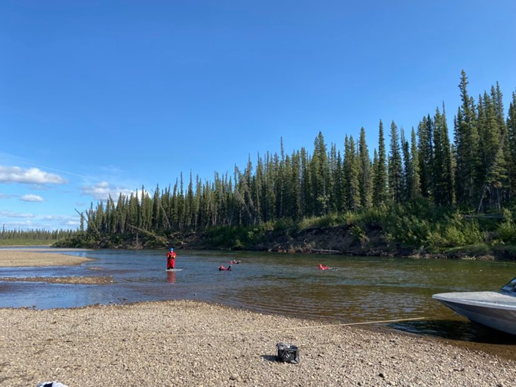 A small group of Nę K’ǝ́dı́ Ke Land Guardians practicing whitewater rescue on the Dehcho (Mackenzie River), with their instructor Caleb Roberts.