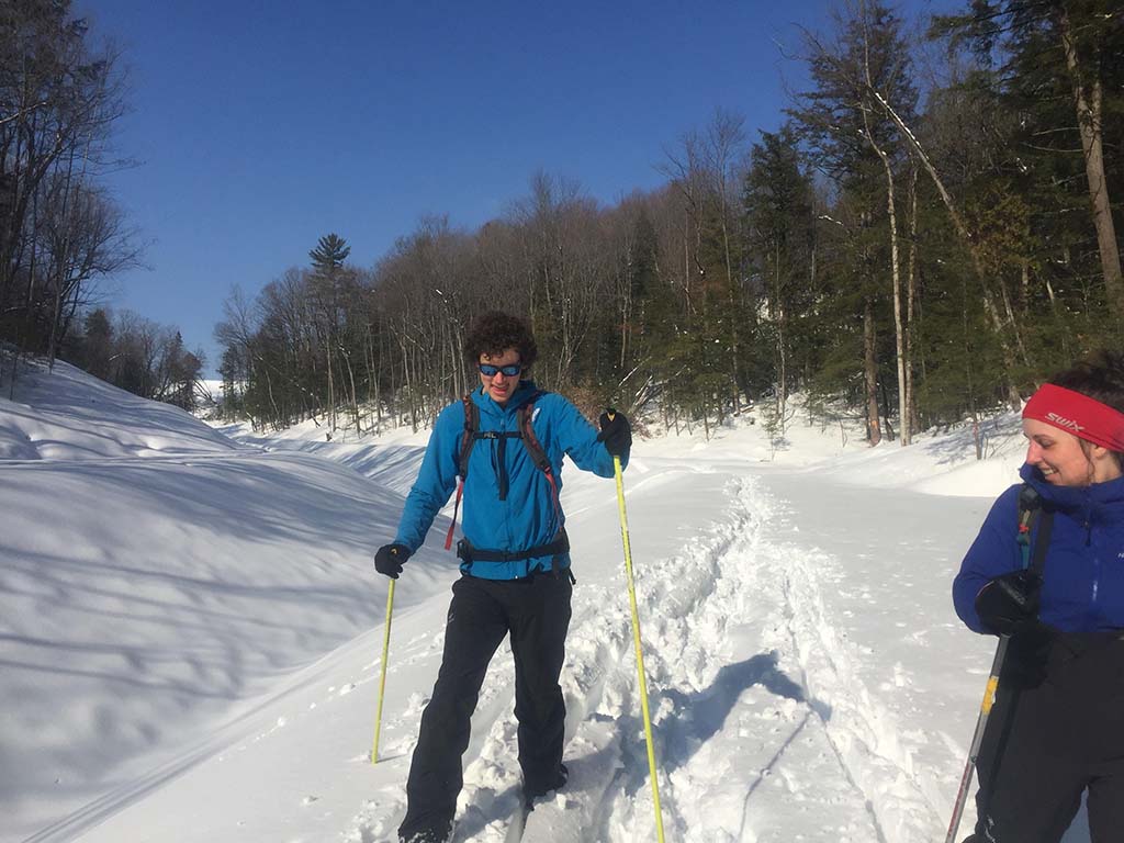 Two cross country skiers smiling on a sunny day